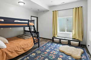Bedroom with wood finished floors and baseboards
