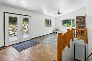 Entrance foyer featuring vaulted ceiling, french doors, and a ceiling fan