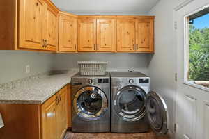 Laundry area featuring cabinet space and washer and clothes dryer