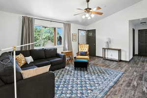 Living room featuring vaulted ceiling, wood finished floors, and ceiling fan