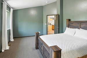 Bedroom featuring light colored carpet and white fridge with ice dispenser