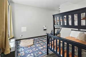 Bedroom with wood finished floors and multiple windows