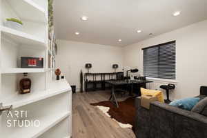 Bedroom 5, configured as office space featuring light wood floors, built-in bookcases and recessed lighting