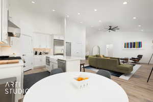 Great room featuring recessed lighting, light wood finished floors, high vaulted ceiling, and a ceiling fan