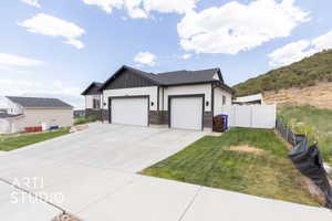 View of front of property featuring board and batten siding, a garage, driveway, RV parking, and stone siding