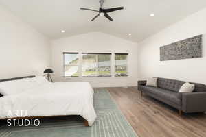 Primary Bedroom Suite featuring wood finished floors, view of backyard, lofted ceiling, recessed lighting, and a ceiling fan