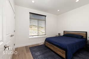 Bedroom 3 with wood finished floors and recessed lighting with view to the West