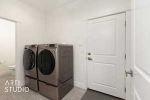 Laundry area with washer and clothes dryer and baseboards with 1/2 Bath