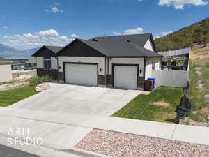 Ranch-style home with a garage, a mountain view, board and batten siding, and driveway