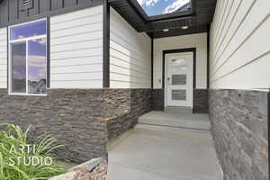 View of exterior entry featuring stone siding
