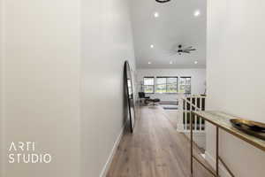 Entry corridor featuring an upstairs landing, light wood floors, and recessed lighting