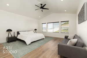 Primary Bedroom Suite featuring wood finished floors, view of backyard, lofted ceiling, recessed lighting, and a ceiling fan