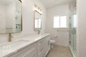 Full bath featuring double vanity and a marble finish shower