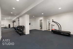 Living room configured as exercise room with an exterior entrance, kitchenette, textured ceiling, and recessed lighting