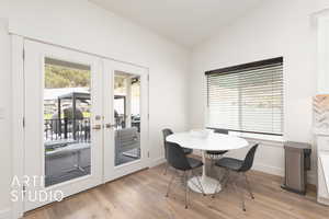 Dining space with french doors,wood flooring, and lofted ceiling