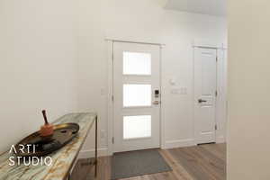 Doorway with light wood floors and plenty of natural light