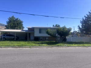 Split level home featuring a carport and a metal roof