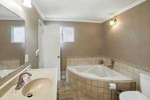 Full bath with a textured wall, a bath, tile patterned flooring, crown molding, and vanity