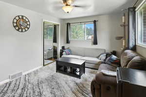Living area featuring ceiling fan and baseboards