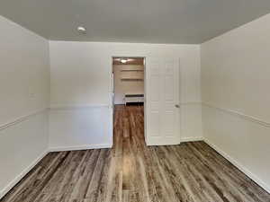Empty room with wood finished floors and radiator