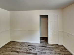 Unfurnished bedroom featuring wood finished floors and baseboards