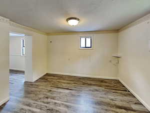 Empty room with wood finished floors and a textured ceiling