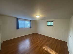 Unfurnished room with wood finished floors and baseboards