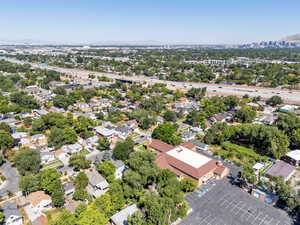 Aerial view of property and surrounding area featuring nearby suburban area and a mountainous background