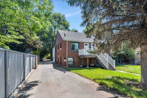 View of front of property with brick siding, a shingled roof, and stairway
