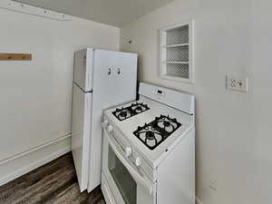 Kitchen featuring white appliances and dark wood-style flooring