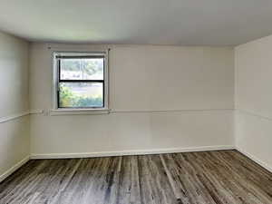 Unfurnished room featuring wood finished floors and baseboards