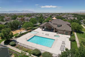 Community pool with a residential view, a patio, a hot tub, and a mountain view