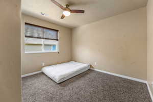 Carpeted bedroom with baseboards and ceiling fan
