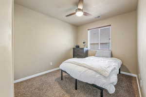 Carpeted bedroom featuring baseboards and a ceiling fan