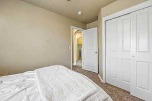 Carpeted bedroom with arched walkways and a closet