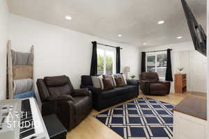 Living area with wood finished floors, a textured ceiling, and recessed lighting