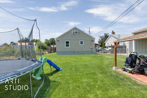 Fenced backyard featuring a trampoline
