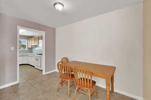 Dining space with light tile patterned floors and a textured ceiling