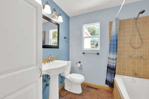 Full bath with shower / bathtub combination with curtain and tile patterned floors