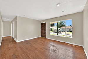 Unfurnished room with hardwood / wood-style flooring and a textured ceiling