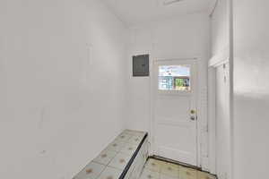 Doorway with electric panel and light flooring