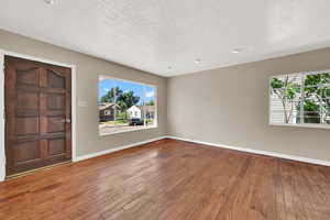 Entrance foyer with a textured ceiling and hardwood / wood-style floors