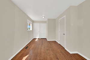 Unfurnished bedroom with baseboards and wood finished floors
