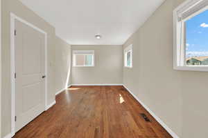 Unfurnished room with wood finished floors and baseboards