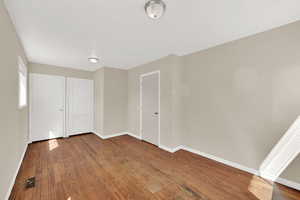 Unfurnished bedroom featuring wood finished floors and baseboards