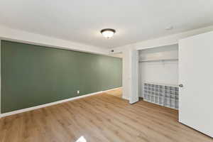 Unfurnished bedroom featuring wood finished floors and a closet
