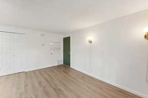 Unfurnished bedroom featuring light wood finished floors and a closet