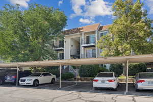 View of building exterior featuring covered parking
