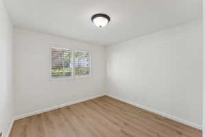 Unfurnished room with light wood-style flooring and a textured ceiling