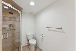 Full bath with a shower stall and tile patterned floors